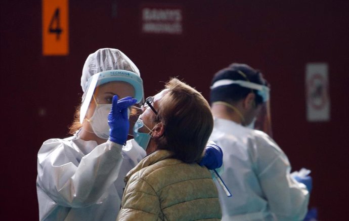 14 December 2020, Spain, Lloseta: A health worker conducts a test for coronavirus (Covid-19) for a man where the government of the Balearic Islands is carrying out massive tests on the population following the increase in coronavirus infections. Photo: 