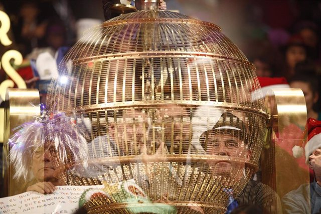 Personas disfrazadas detrás de un bombo esperan en el Teatro Real de Madrid para disfrutar del Sorteo Extraordinario de la Lotería de Navidad. 