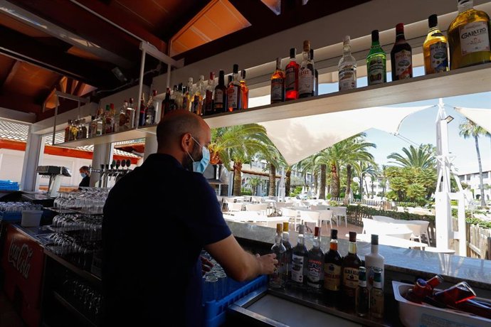 Camarero atiende una barra de bar en Alcúdia.