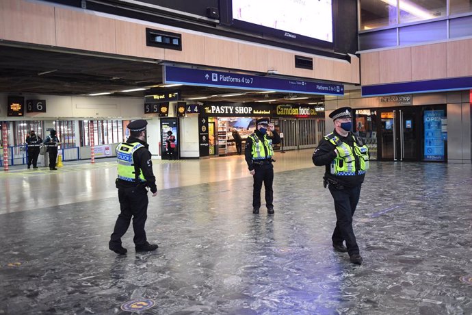 20 December 2020, England, London: Police officers walk at Euston Station, as more police forces are deployed to enforce travel rules at London's stations. British Prime Minister Boris Johnson announced a strict lockdown and cancelled Christmas holiday 