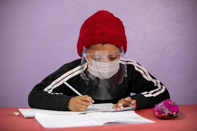 Un estudiante con mascarilla en Katmandú