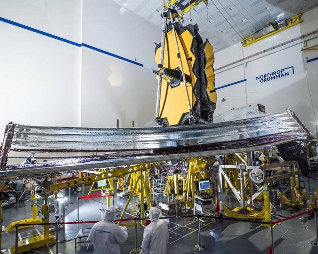 Para ayudar a garantizar el éxito, los técnicos inspeccionan cuidadosamente el parasol del telescopio espacial James Webb antes de que comience la prueba de despliegue.