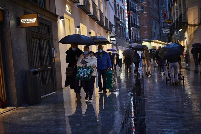 Transeúntes caminan cerca de una zona comercial en la calle de Preciados