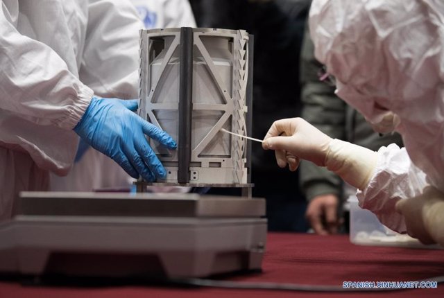 Imagen de un trabajador limpiando la superficie del contenedor cargado con muestras lunares obtenidas por la sonda espacial Chang'e-5