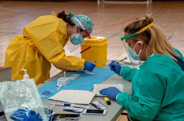 Sanitarios trabajando durante las pruebas de cribado de covid-19 con test de antígenos en el pabellón deportivo de 'El Paraguas'. En Sevilla (Andalucía, España), a 28 de octubre de 2020.