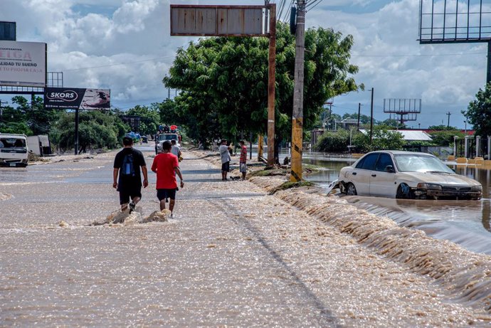 19 November 2020, Honduras, La Lima: People walk on a flooded highway after the devastating hurricane Iota made landfall in Honduras. Photo: Seth Sidney Berry/SOPA Images via ZUMA Wire/dpa