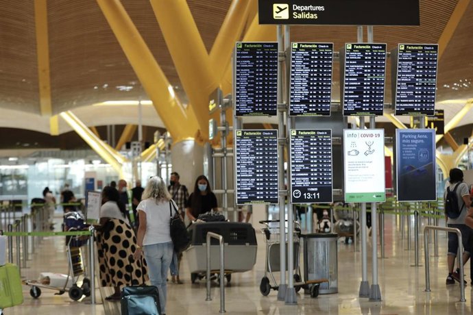 Pasajeros junto a páneles de información en la Terminal T4 del aeropuerto Adolfo Suárez Madrid-Barajas, en Madrid (España), a 11 de septiembre de 2020. Los aeropuertos de la red de Aena, el Adolfo Suárez Madrid-Barajas entre ellos, cerraron agosto con u