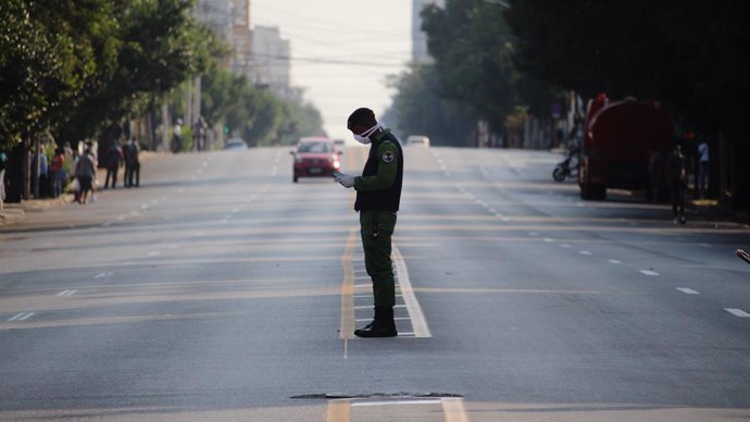 04 April 2020, Cuba, Havana: A policeman wears a face mask as he stands in a deserted street. Cuba has sealed off a part of downtown Havana popular with tourists because of the Coronavirus pandemic. Photo: Guillermo Nova/dpa