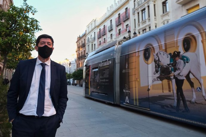Juan Marín junto al tranvía de Sevilla con publicidad de Jerez