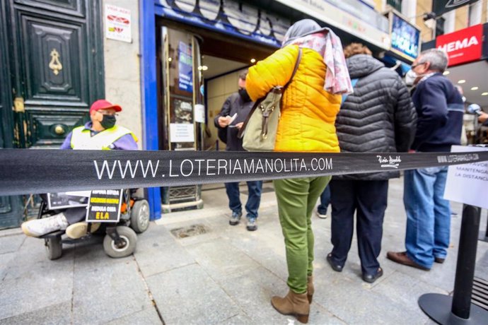 Varias personas hacen cola para entrar a la administración de lotería Doña Manolita.