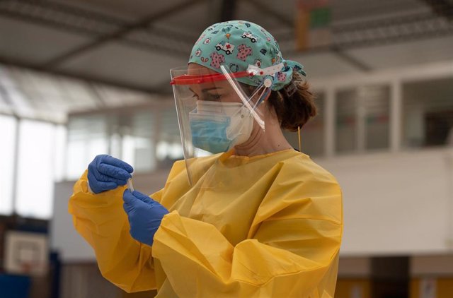 Una sanitaria atiende a una mujer durante las pruebas de cribado de covid-19 con test de antígenos en el pabellón deportivo de 'El Paraguas'. En Sevilla (Andalucía, España), a 28 de octubre de 2020.