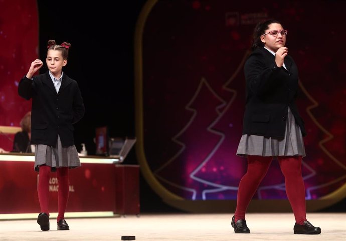 Dos de las niñas de la residencia de San Ildefonso, Judith García Benítez (i) y  Nerea Pareja Martínez (d) cantan el segundo premio de la Lotería de Navidad, el `52.472  durante la celebración del Sorteo Extraordinario de la Lotería de Navidad 2020.