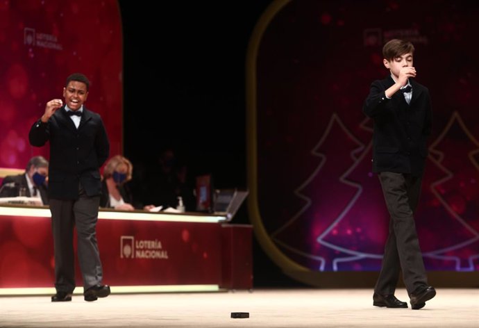 Uno de los niños de la residencia de San Ildefonso, Alexander René Herrera (i) y Unai Barón Maldonado (d) cantan el `Gordo de la Lotería de Navidad, el `72.897 durante la celebración del Sorteo Extraordinario de la Lotería de Navidad 2020 en el Teatro R