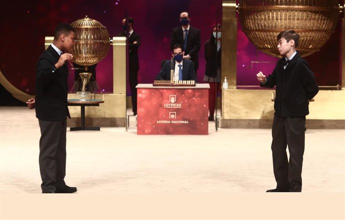 Dos de los niños de la residencia de San Ildefonso, Alexander René Herrera (i) y Unai Barón Maldonado (d) cantan el `Gordo de la Lotería de Navidad, el `72.897 durante la celebración del Sorteo Extraordinario de la Lotería de Navidad 2020 en el Teatro R