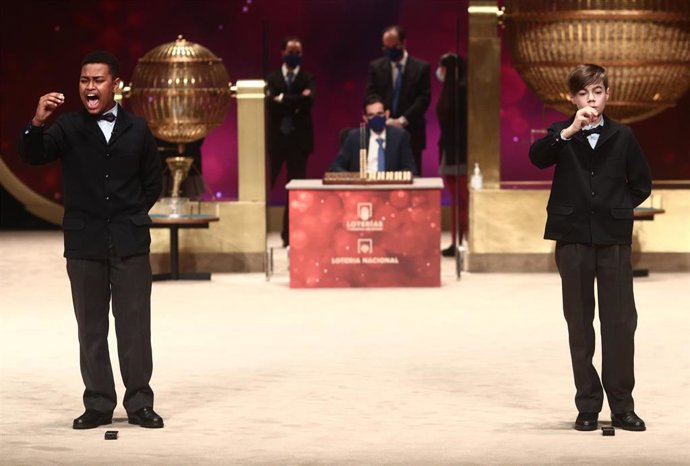 Dos de los niños de la residencia de San Ildefonso, Alexander René Herrera (i) y Unai Barón Maldonado (d) cantan el `Gordo de la Lotería de Navidad, el `72.897 durante la celebración del Sorteo Extraordinario de la Lotería de Navidad 2020 en el Teatro R