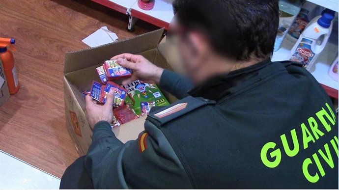 Un agente de la Guardia Civil con el material incautado.