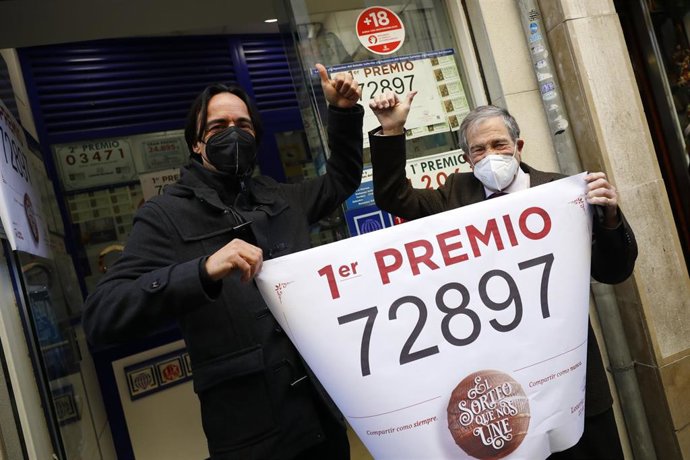 Loteros posan en la administración de lotería situada en la calle Principe 11 , en la que se ha repartido parte del número '72897 correspondiente  a 'El Gordo' de la Lotería de Navidad, en Granada  (Andalucía, España), a 22 de diciembre de 2020