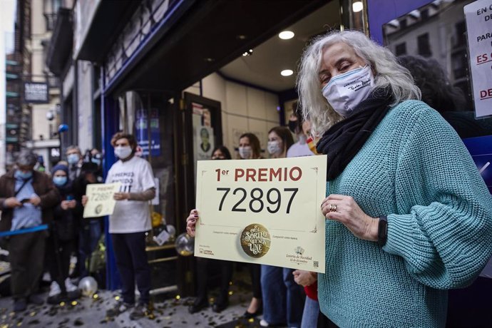 Una lotera posa con `El Gordo en la popular administración de 'Doña Manolita', en el número 22 de la calle Carmen del centro de la capital 