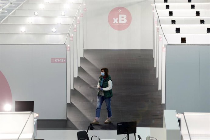 Una mujer pasa por los pasillos que comunican 