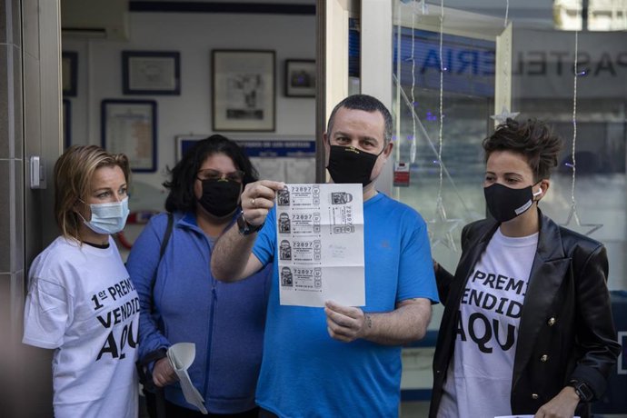 Emiliano e Irene,  su mujer, celebran `El Gordo junto a las loteras en la administración de Punta Umbría (Huelva) en la que se ha repartido parte del número `72.897 correspondiente a 'El Gordo' de la Lotería de Navidad.