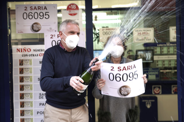 Loteros de la administración de Lotería de Barakaldo en la que se ha repartido parte del número 06095 correspondiente al Segundo Premio del Sorteo Extraordinario de Lotería de Navidad 2020, descorchan una botella de cava 