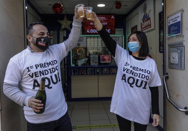 Dos loteros celebran `El Gordo con champán en la administración de lotería situada en la calle Doctor Navarro,19  en Alfara del Patriarca, (Valencia)