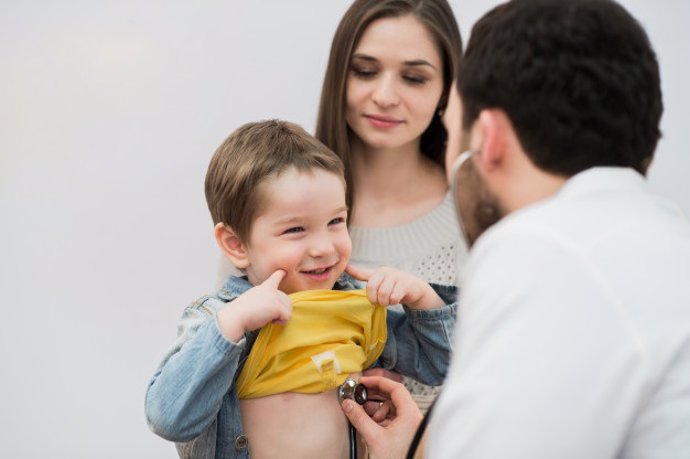 Pediatra atiende a un niño junto a su madre