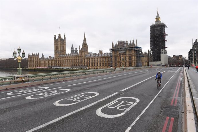 22 December 2020, England, London: A cyclist rides on the empty Westminster Bridge in London amid a strict lockdown due to the spread of the new variant coronavirus. Photo: Stefan Rousseau/PA Wire/dpa