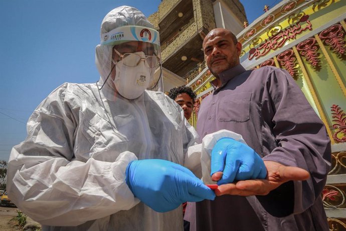Un trabajador sanitario de Irak toma una muestra de sangre durante la pandemia de coronavirus