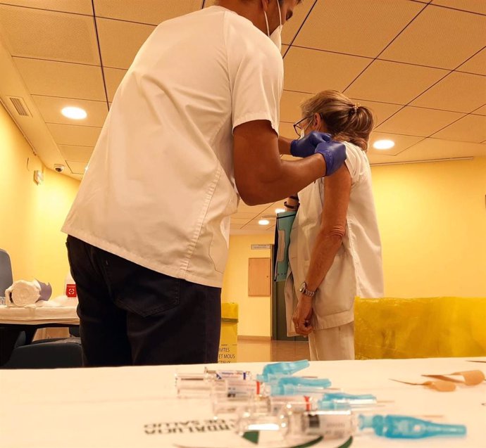 Imagen de archivo de la vacunación contra la gripe a una profesional sanitaria. 