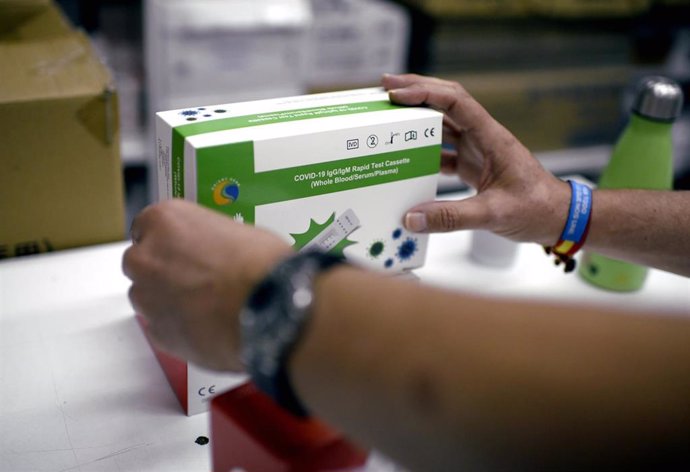 Una farmacéutica coloca una de las cajas de un test de antígeno para Covid-19, en Madrid (España). Como avanzó hace dos días la presidenta de la Comunidad de Madrid, Isabel Díaz Ayuso, se está estudiando que en las farmacias de la región se puedan hacer