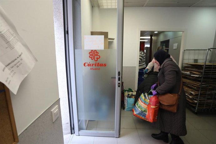 Una mujer con Hiyab sale a la calle tras realizar la compra en el  economato solidario de Cáritas