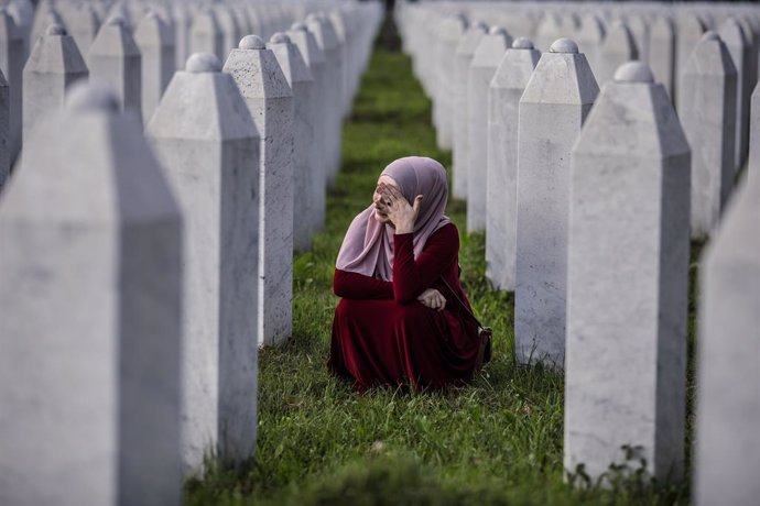 Una mujer llora ante la lápida de su familiar en el cementerio de Potocari, donde descansan los restos mortales de miles de víctimas del genocidio de Srebrenica