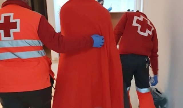 Voluntarios de Cruz Roja atendiendo a una persona migrante (archivo)