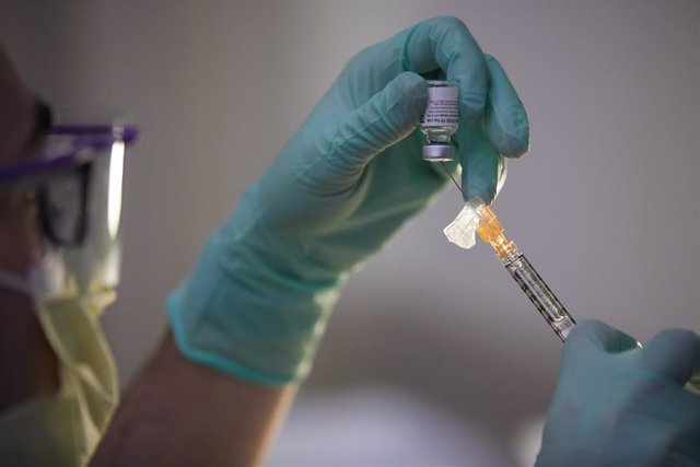21 December 2020, US, Worcester: A man fills a syringe with the Pfizer Coronavirus (Covid-19) vaccine at a vaccination centre in UMass Memorial Hospital in Worcester. Photo: Allison Dinner/ZUMA Wire/dpa