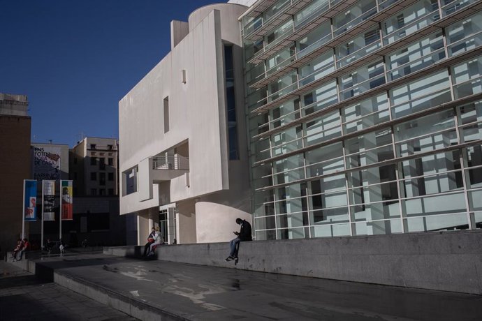 Un hombre sentado frente al Museo de Arte Contemporáneo y Moderno de Barcelona (MACBA), en la primera mañana después del toque de queda en la ciudad, en Barcelona, Catalunya (España), a 26 de octubre de 2020. 