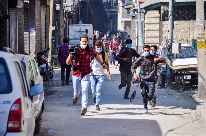 Un grupo de periodistas corre durante los enfrentamientos que tuvieron lugar en unas recientes manifestaciones en Cachemira por la muerte de tres personasa a manos de las autoridades de India.
