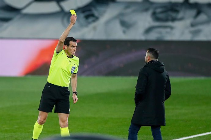 Juan Martinez Munuera, referee of the match, shows the yellow card to Diego Martinez, head coach of Granada, during the spanish league, La Liga Santander, football match played between Real Madrid and Granada CF at Ciudad Deportiva Real Madrid on decemb