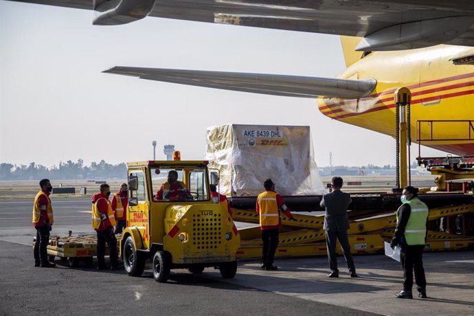 Trabajadores del aeropuerto de Ciudad de México descargan cargamento de la vacuna de Pfizer.