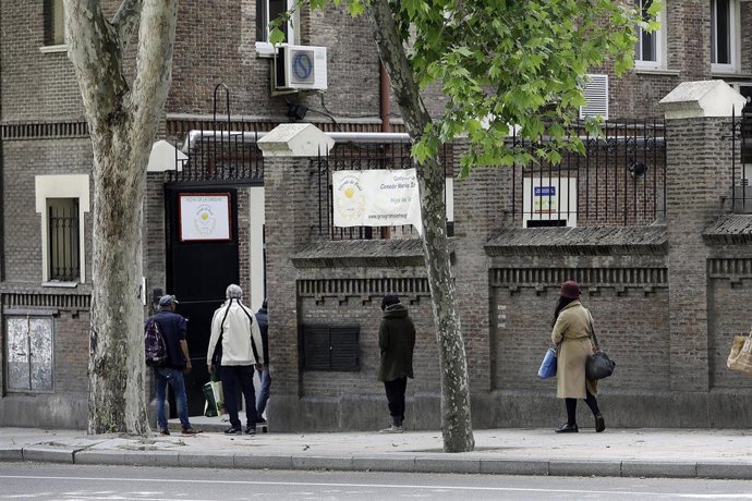 Decenas de personas esperan en la cola a las puertas del Comedor Social María Inmaculada de Madrid. 