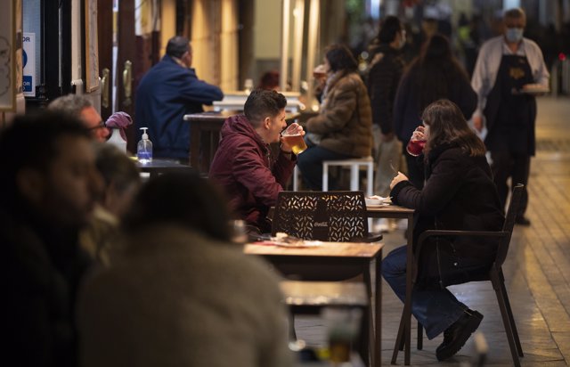 Varias personas en la terraza de un bar tras la apertura de bares y restaurantes de Sevilla, Andalucía, a 18 de diciembre de 2020