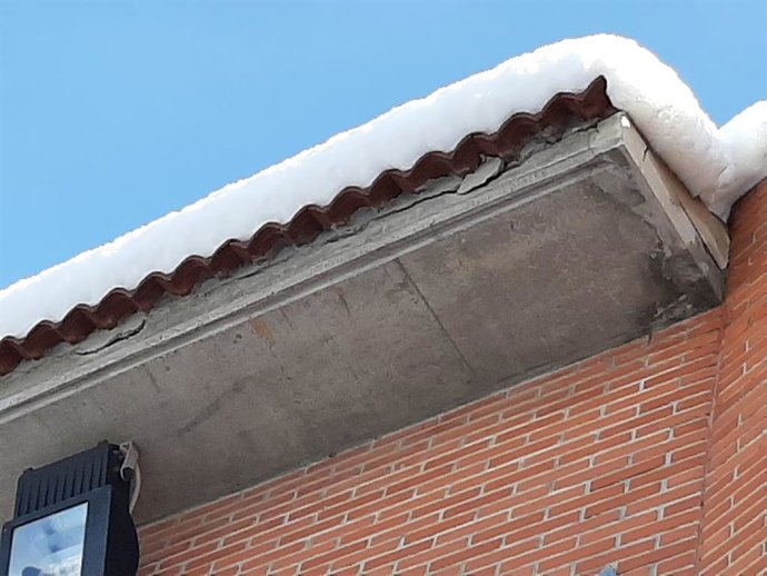 Cornisa nevada de una vivienda.