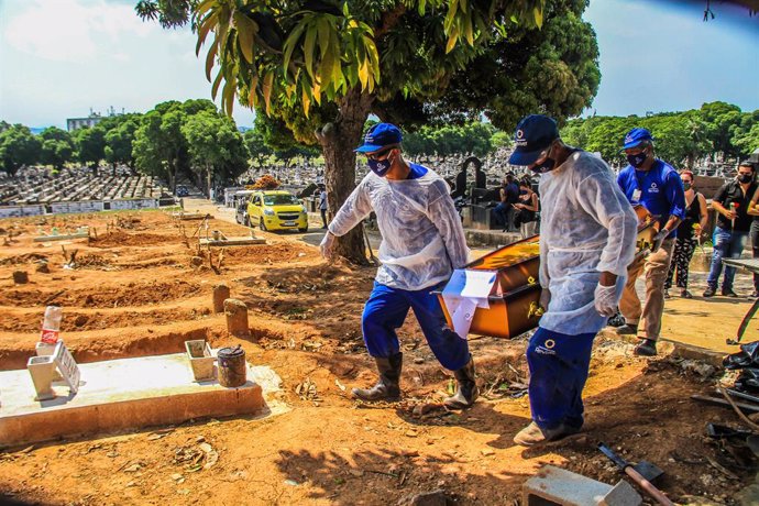 16 December 2020, Brazil, Rio de Janeiro: Relatives and medics in protective suits carry the body of a man who died from the coronavirus (COVID-19) at Sao Francisco Xavier cemetery. Photo: Ellan Lustosa/ZUMA Wire/dpa