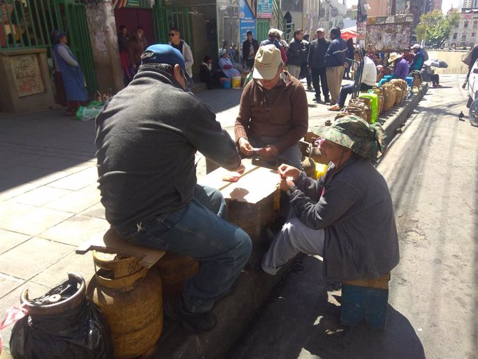 Bolivianos esperan para hacerse con bombonas de gas en La Paz.