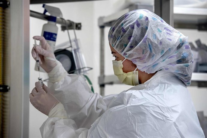 14 December 2020, US, New Mexico: A pharmacy technician at Christus St. Vincent Hospital, adds saline to vials of the Pfizer coronavirus (COVID-19) vaccine. Photo: Eddie Moore/Albuquerque Journal via ZUMA/dpa