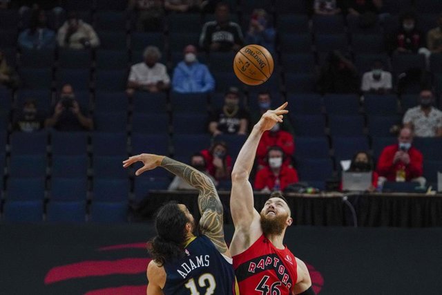 Aron Baynes, de Toronto Raptors, y Naji Marshall, de New Orleans Pelicans, saltan en el estreno de ambos en la NBA 2020/21