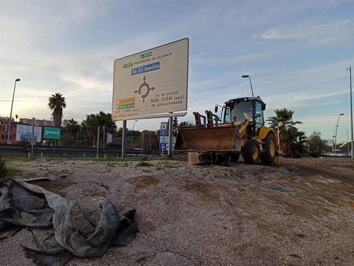 Una máquina retro excavadora en la zona donde se situará uno de los extremos de la pasarela