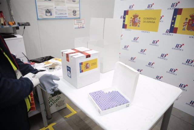 Personal de los laboratorios que han desarrollado las vacunas, Pfizer y BioNtech entregan las dosis a técnicos de la Agencia Española de Medicamentos y Productos Sanitarios para su certificación y a personal del Ejército que recogen las vacunas para lleva