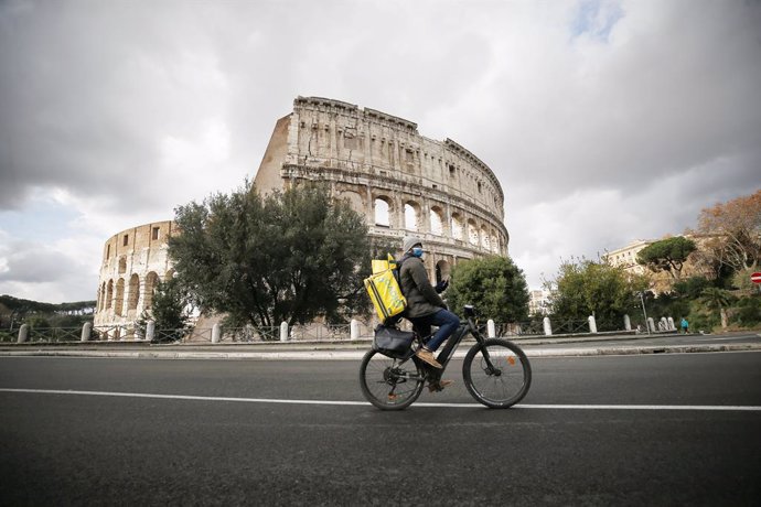 Un ciclista de reparto frente al Coliseo de Roma