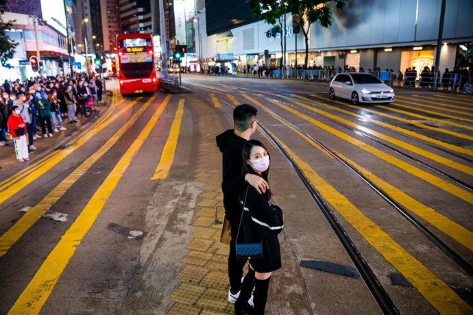 Una pareja cruza una calle en Hong Kong.